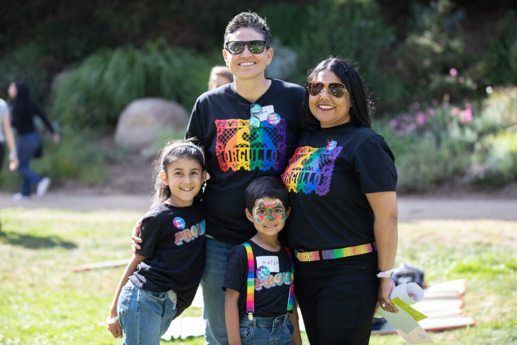 photo of family with queer parents and 2 young kids at pride event