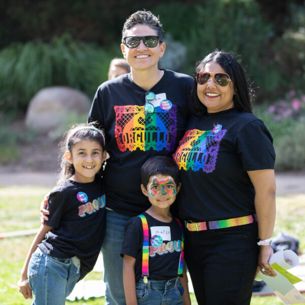 photo of family with queer parents and 2 young kids at pride event